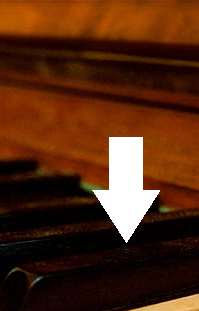 Closeup of an old piano. A B-flat key is indicated