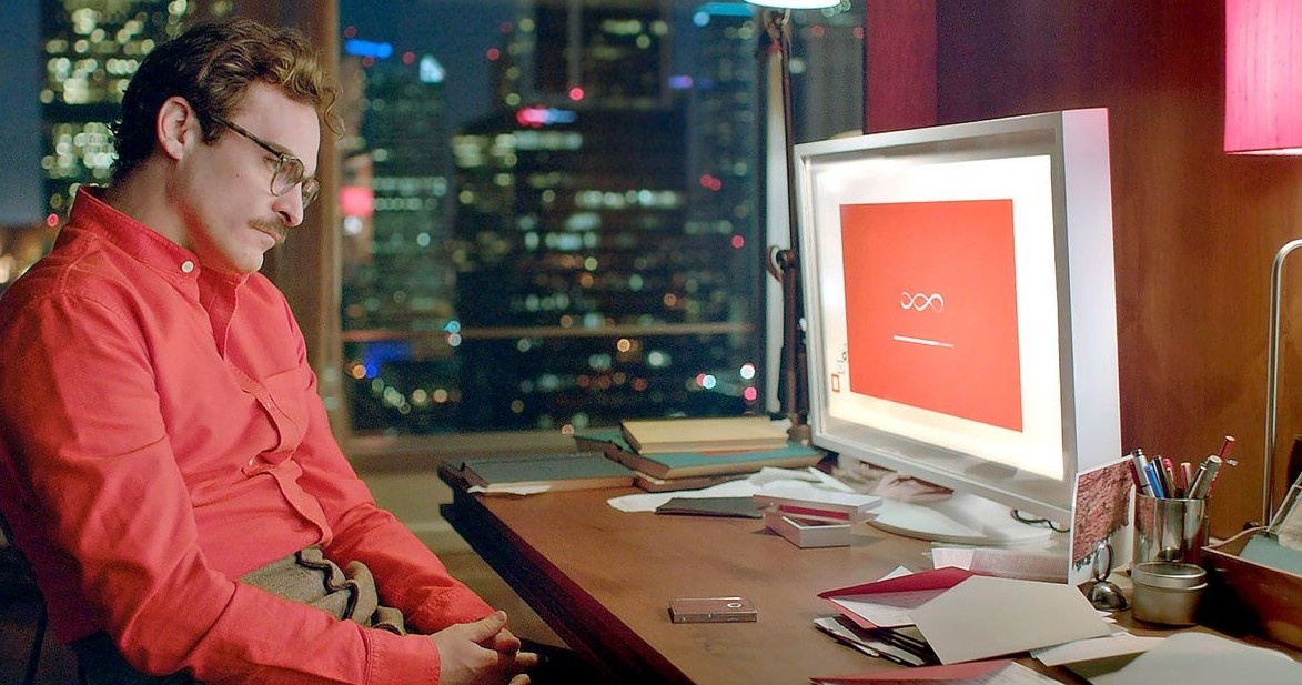 Film still where Joaquin Phoenix's character is having an earnest conversation with a scarlett computer screen.